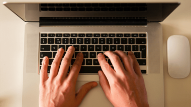 Hands typing on laptop computer