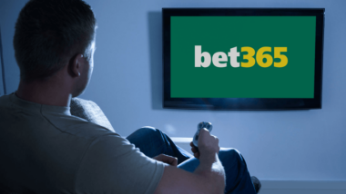 Man watching TV with betting logo